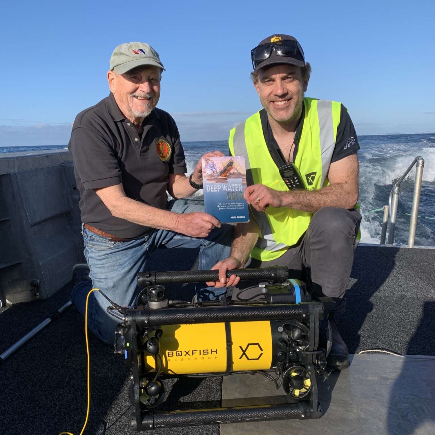 Ben King with Keith Gordon and Boxfish ROV after dive to RMS Niagara holding Keith's book about RMS Niagara